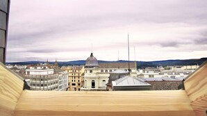 Uitzicht vanuit een raam op een stadsgezicht met historische gebouwen en een opvallende koepel.