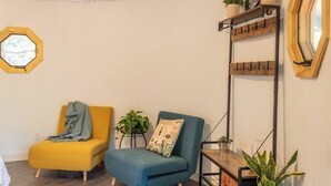 Une pièce comprenant deux chaises, une petite table et une étagère avec des plantes.
