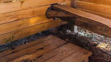 A wooden bench with a metal structure attached to it, possibly for hanging items.