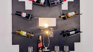 Un porte-bouteilles à vin fixé au mur, pouvant contenir plusieurs bouteilles et verres.