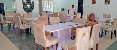 A conference room with a large table and multiple chairs, a chandelier, and artwork on the walls.