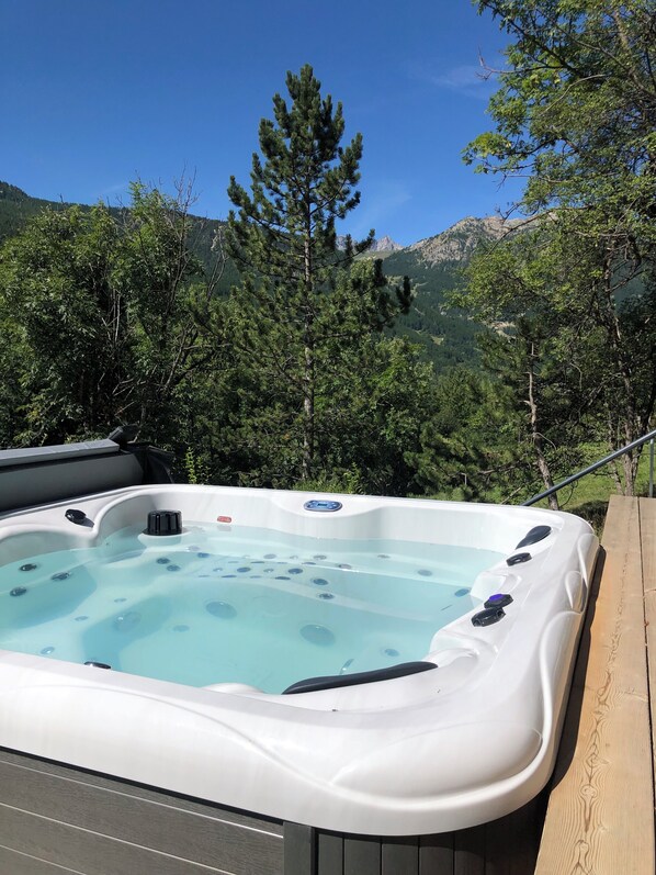 A hot tub with a clear view of the surrounding forest and mountains. - Spacious chalet with an unobstructed view of the valley (La Salle-les-Alpes)