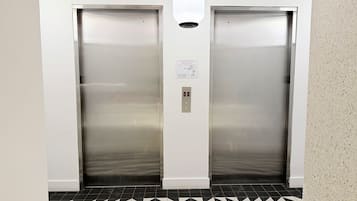 An elevator with a control panel and emergency instructions.