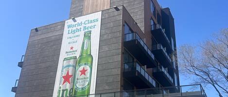 A modern building with a large Heineken advertisement on the side.