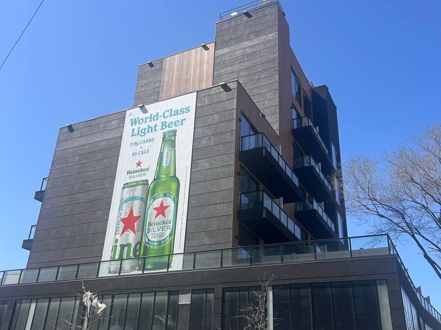 A modern building with a large Heineken advertisement on the side.