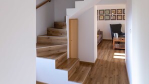 Una escalera con escalones de madera y una pared gris.