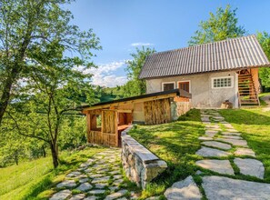 Una casa rústica con un sendero de piedra que lleva a un porche de madera.