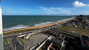 A coastal cityscape with a beach, roads, and buildings. - RN STUDIO APTO 1002 (Maceió)