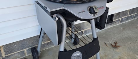 Una parrilla Char-Brool con tapa negra y una etiqueta que dice "NUEVO" en la parte frontal.