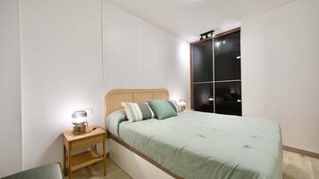 1 dormitorio y tabla de planchar con plancha
