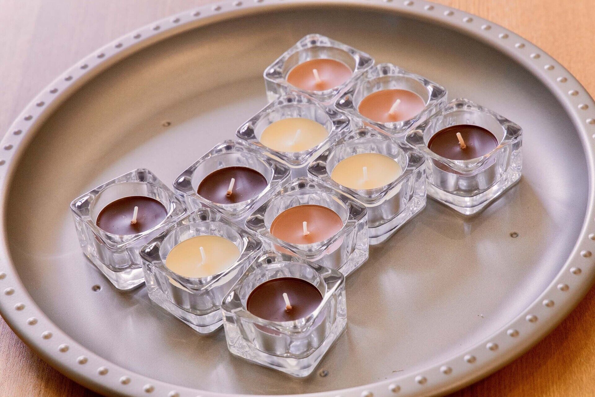 Una bandeja con varios candelabros de vidrio que contienen velas.