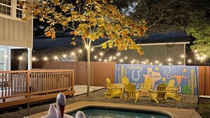 A backyard with a swimming pool, inflatable swan, and outdoor seating. - HotTub, Pool, FirePit, Game Room, BBQ, Volleyball and a ton of Family Fun! (San Antonio)