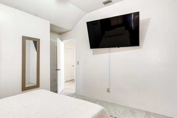 A bedroom with a bed, a TV mounted on the wall, and a door leading to another room. - 3 Mi to Marina: Riverview Family Home w/ Lanai! (Riverview)