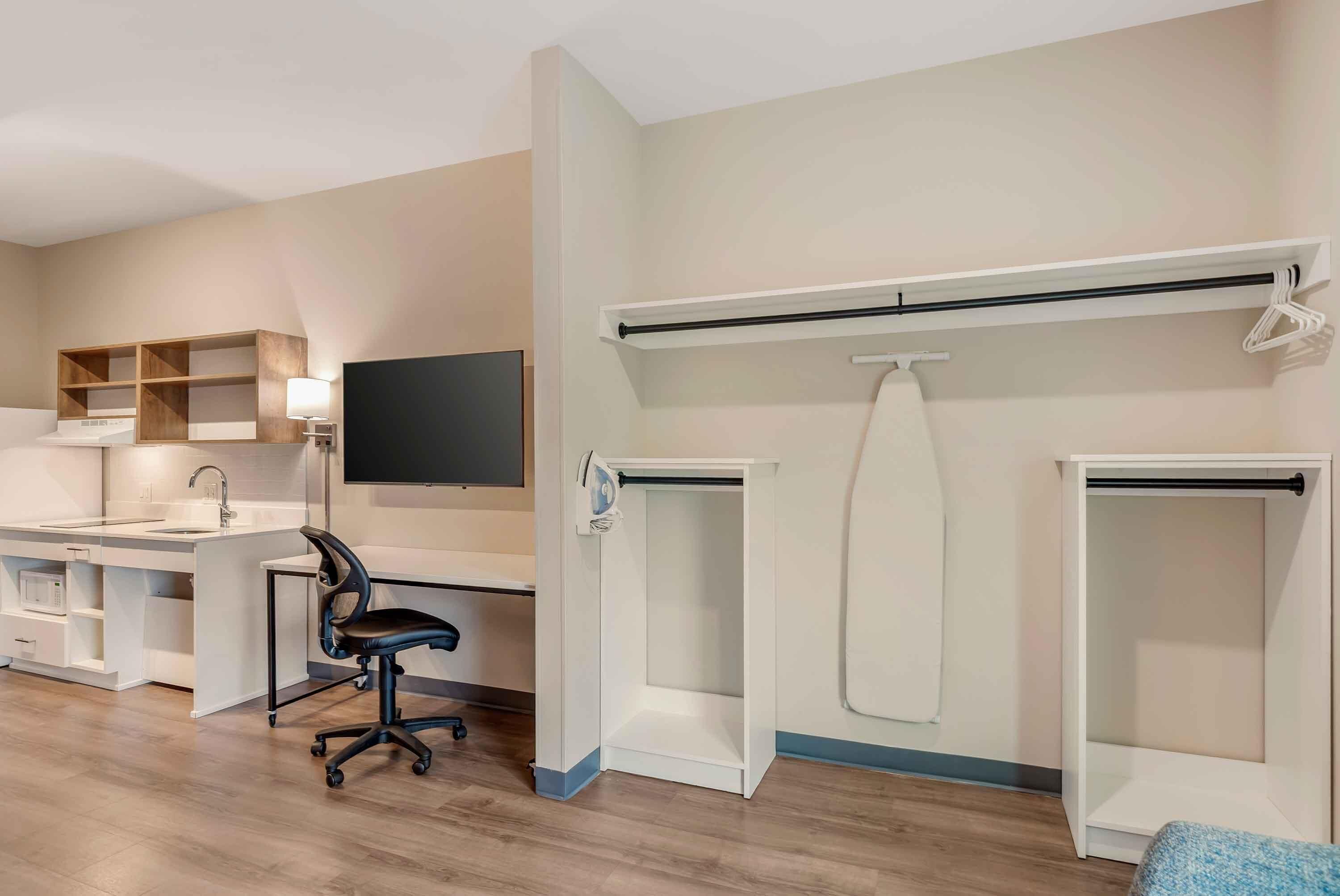 A modern room with a desk, chair, and built-in shelving.