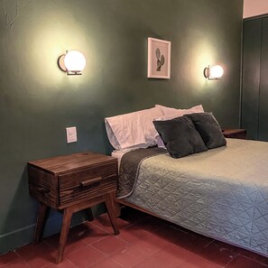 A bedroom with a bed, bedside tables, and wall-mounted lights. - Casa Sabina (Guadalajara)