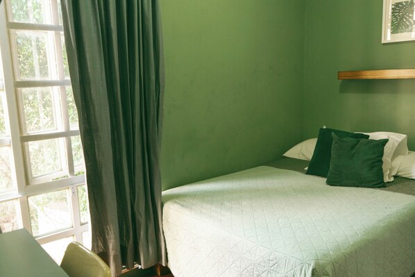 A room with a bed, a window with curtains, and a wall-mounted shelf. - Casa Sabina (Guadalajara)