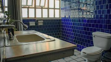 Un baño con lavamanos, inodoro y ventana con vistas al exterior.