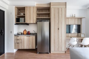 Una cocina moderna con refrigerador, microondas y estufa incorporados.