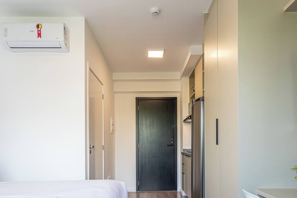Ein modernes Hotelzimmer mit Bett, Schreibtisch und Kühlschrank.
