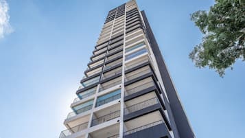 Um edifício alto com várias varandas e céu claro.