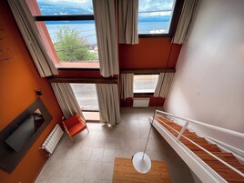 Un interior con varios niveles, vista al mar, una escalera y una zona de estar.