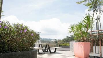 An outdoor seating area with a bench and potted plants.