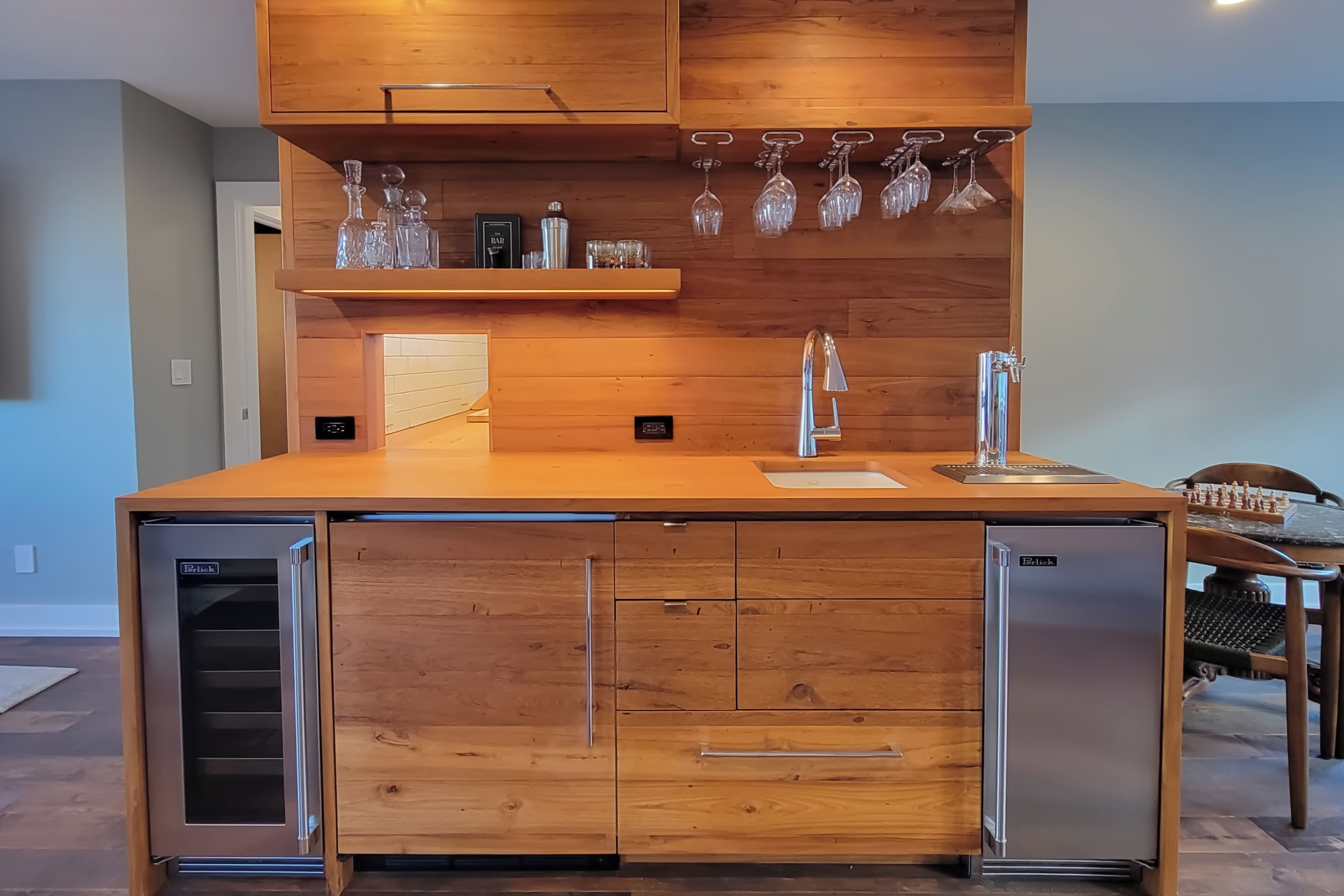 A modern kitchen with a wooden countertop, stainless steel appliances, and a wine rack.
