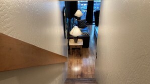 Eine Holztreppe führt zu einem Essbereich mit Tisch und Stühlen, sowie zwei Lampen auf dem Tisch.