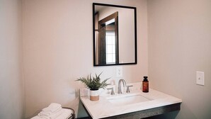 A bathroom with a white sink, a mirror, and a towel rack. - Glamping Dome #4 in Snowshoe, Wv (Snowshoe)