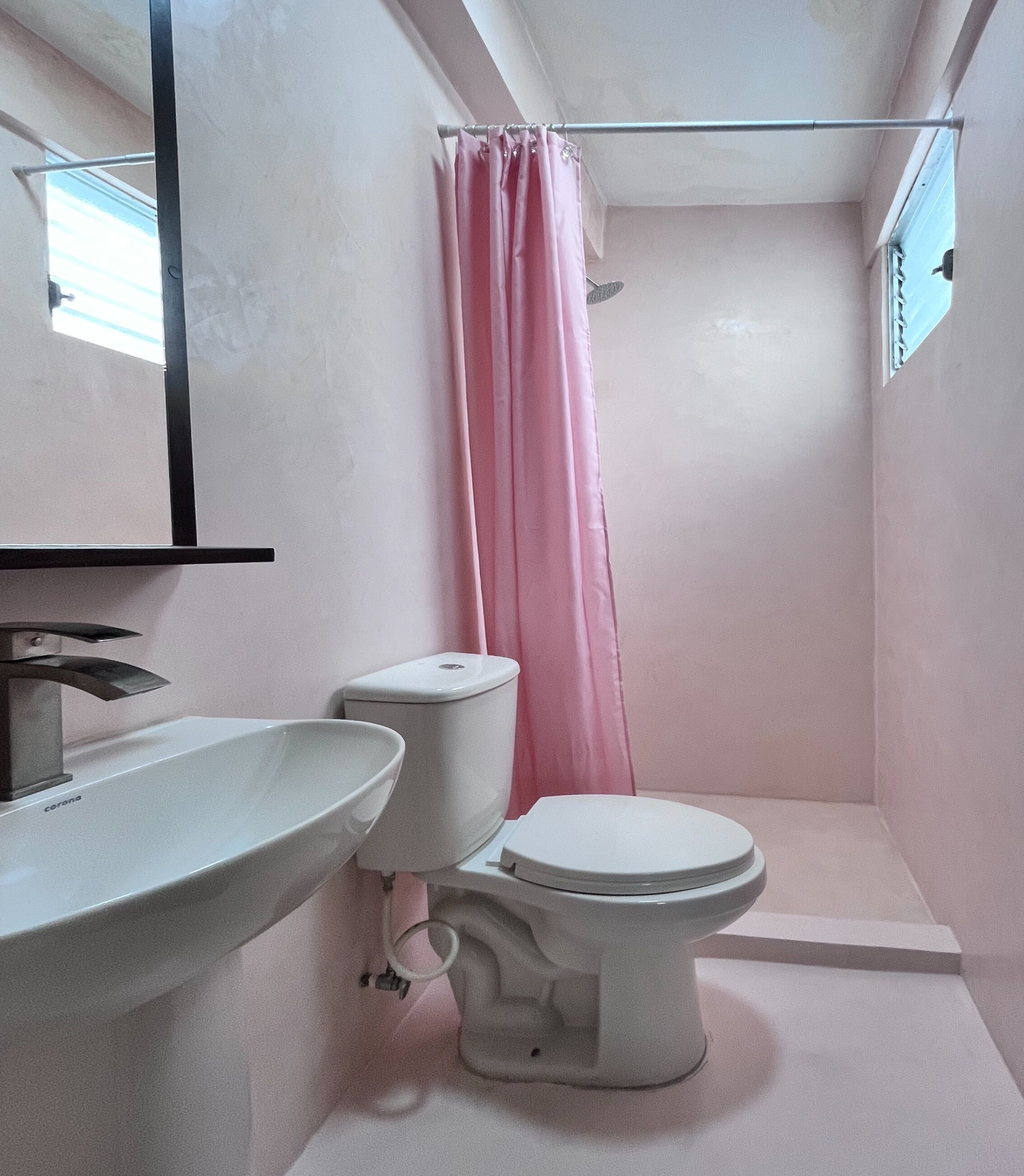 A bathroom with a white sink, toilet, and shower curtain.