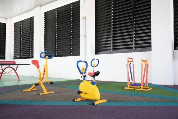 A fitness area with exercise equipment including a stationary bike, a rowing machine, and a leg press. - Modern Suite@Midhills Genting Highlands (Free WiFi) (Genting Highlands)