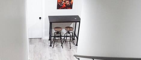Een trap die leidt naar een eetgedeelte met een tafel en stoelen.