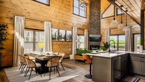 Un vaste espace de vie comprenant une table à manger, un canapé et un îlot de cuisine.