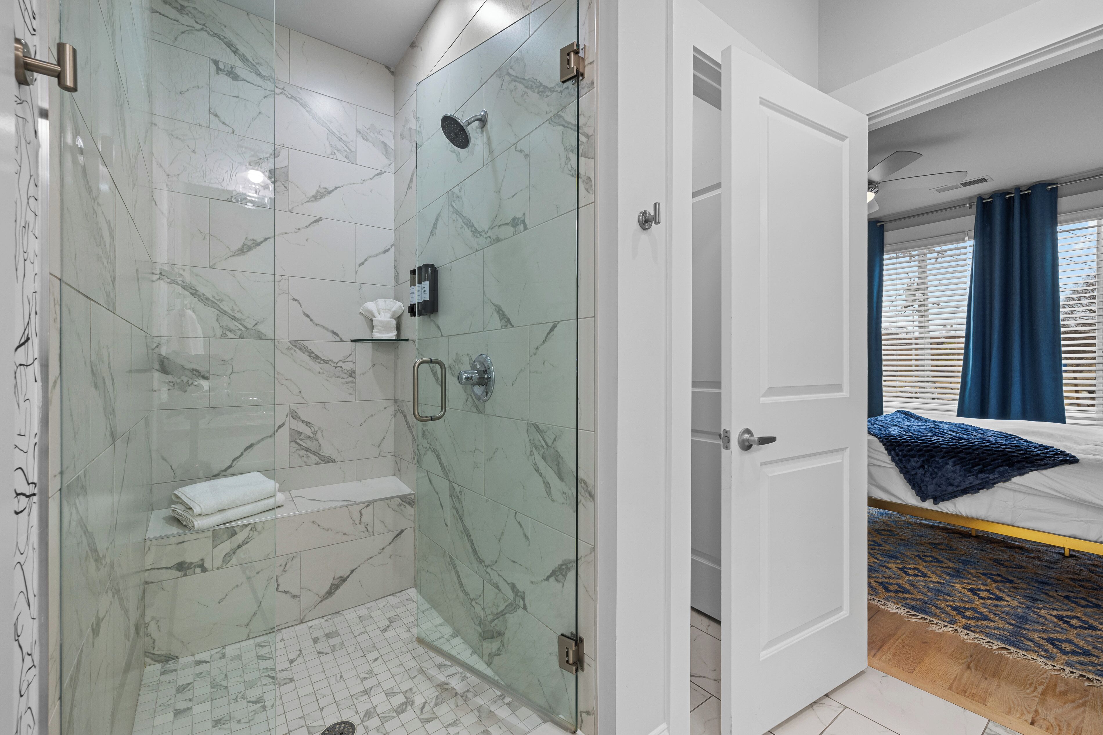 Un baño moderno con ducha de vidrio, inodoro blanco y lavamanos blanco.
