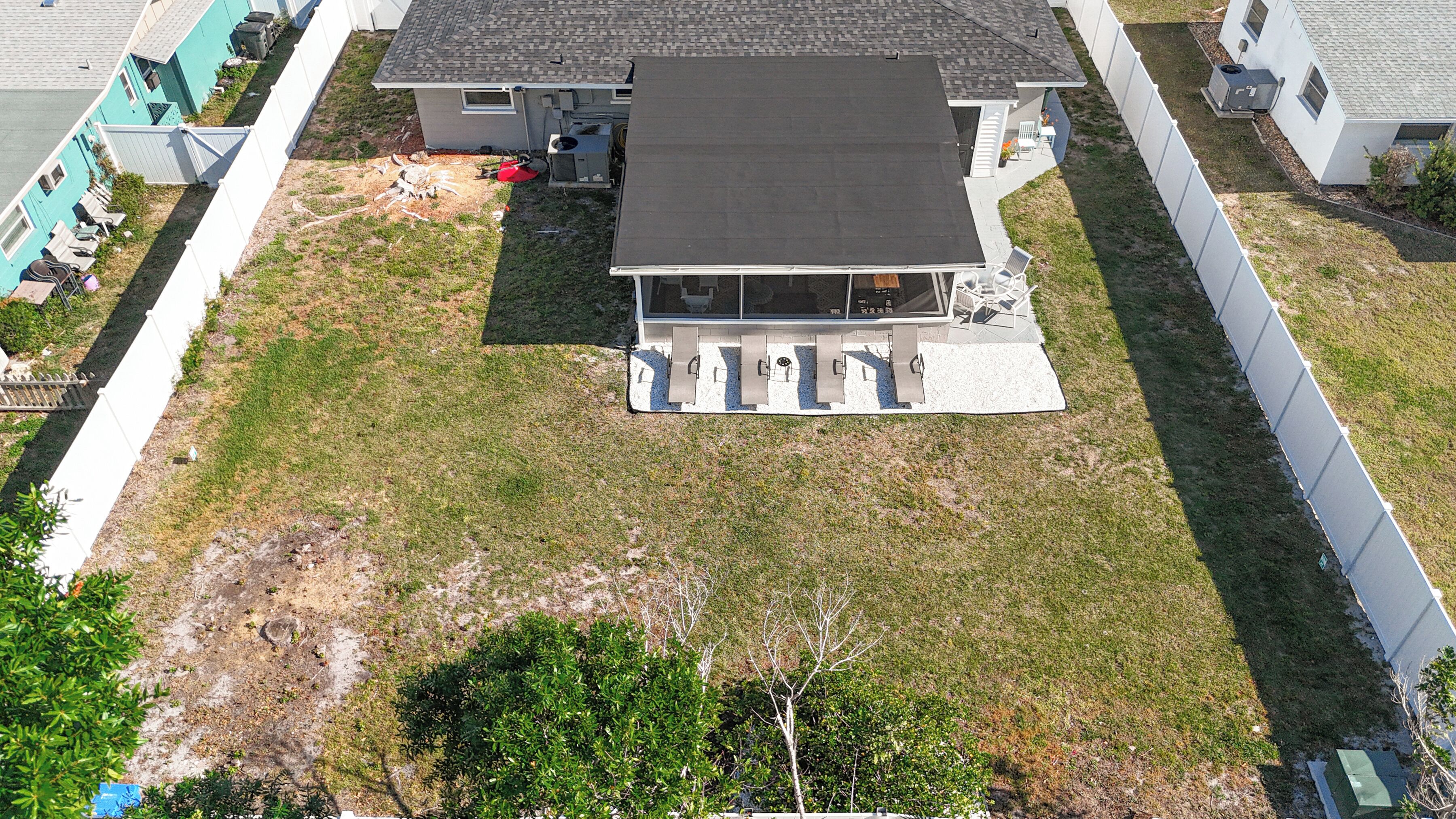 A residential house with a flat roof, a covered patio area, and a small front yard.