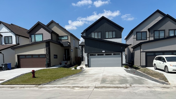 A residential street with modern houses, a driveway, and a white car parked in the driveway. - Luxury: Home Away from Home with Private Entrance  (Winnipeg)