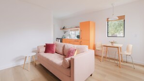 Una sala moderna con un sofá, una mesita y un comedor con sillas.