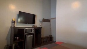 A small kitchenette with a microwave, a small refrigerator, and a TV mounted on the wall. - King Room at Ponds Lodge Cabin 6 Unit 3 (Island Park)