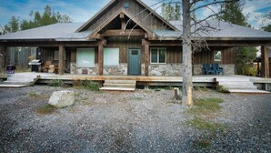 A rustic cabin with a stone foundation, wooden exterior, and a steeply pitched roof. - King Room at Ponds Lodge Cabin 6 Unit 3 (Island Park)