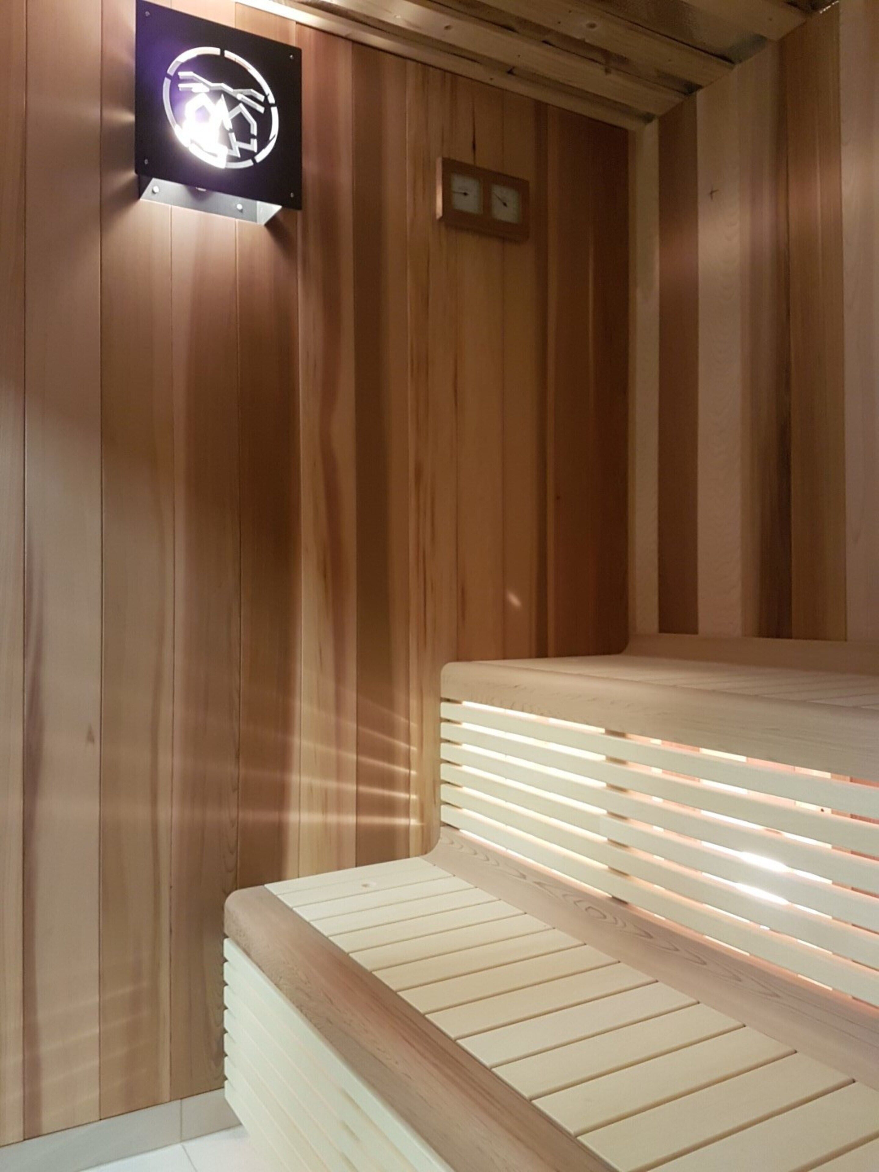 Una sala de sauna con paredes y bancos de madera.