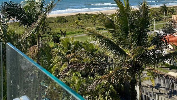 Een balkon met uitzicht op het strand en de oceaan.