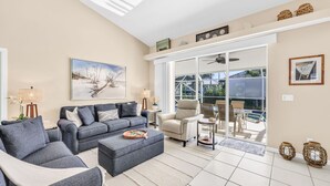 Un salon spacieux comprenant un grand canapé, une table basse et un coin repas avec des chaises et une table.