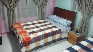 A bedroom with a bed, curtains, a nightstand, and a small table with a plant. - Room-serene Guest Room Retreat in Pasto, (San Juan de Pasto)