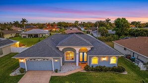Een woonhuis met garage, een verzorgd gazon en een oprit.