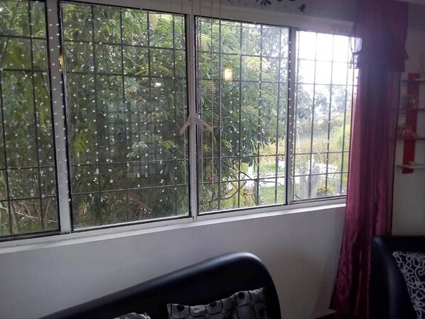 A room with a large window, a bed, and a curtain. - Room-serene Oasis in Pasto Cozy Guest Ro (San Juan de Pasto)