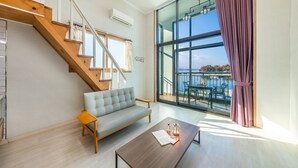Un salon moderne avec un canapé, une table basse et un escalier.