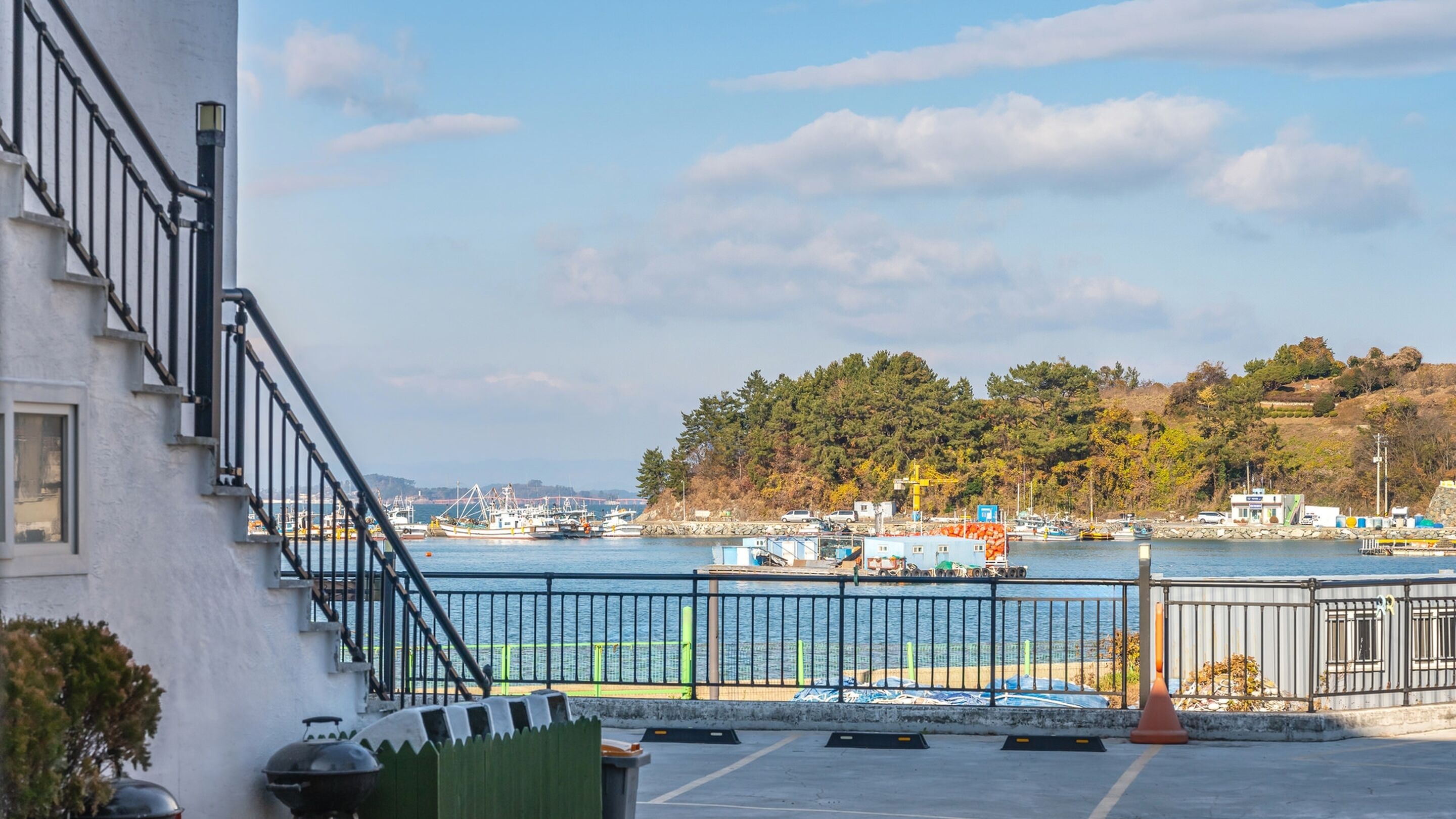 Une vue sur le front de mer, avec un quai, des bateaux et un bâtiment doté d’un escalier.