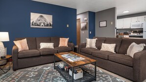 Un salon moderne avec deux canapés, une table basse et un tapis.