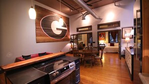 A modern kitchen with a large stove, wooden countertops, and a dining area with chairs and a table.