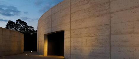 A modern building with a curved facade and a large open entrance.